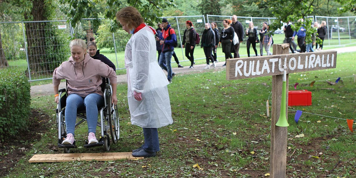 Girl try a wheel chair at the park and participate to rally